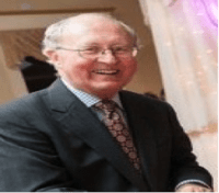 Smiling man in a suit and tie.
